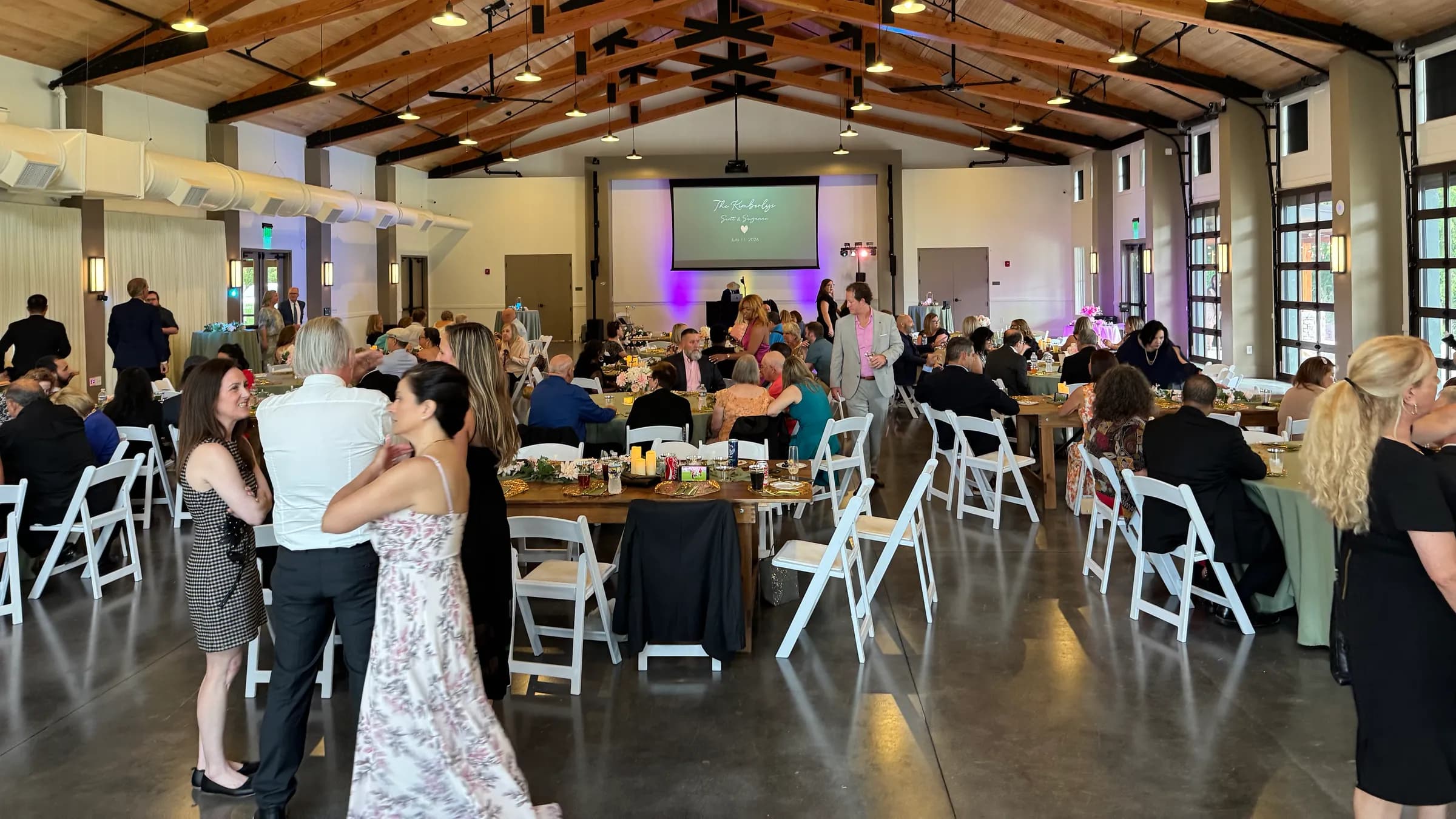 Guests filling the reception hall at long tables during dinner